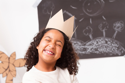 Child girl with paper crown making gesture face