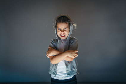 baby girl angry on a gray background