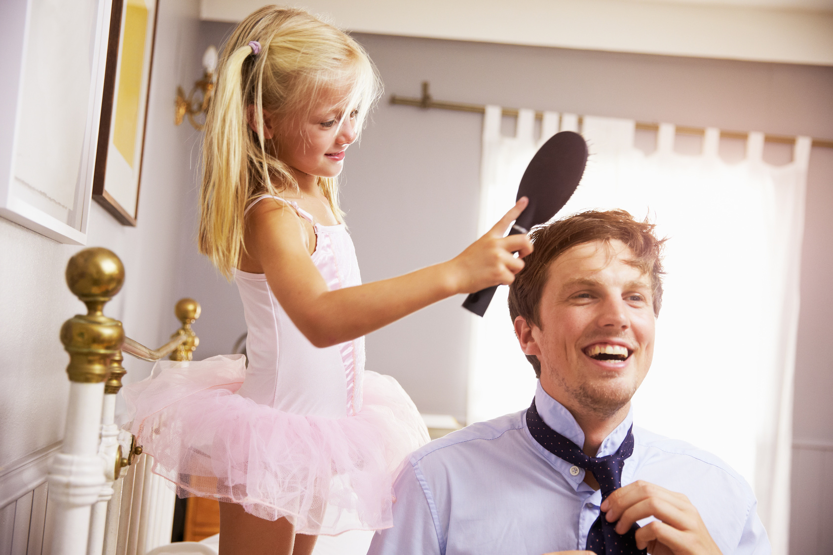 Fillette en robe de princesse qui peigne papa